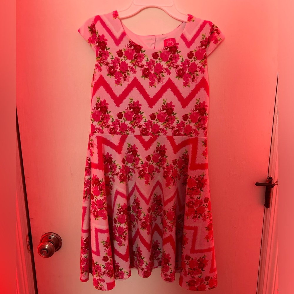 This is a kids size 14 pink floral dress with two buttons on the back.